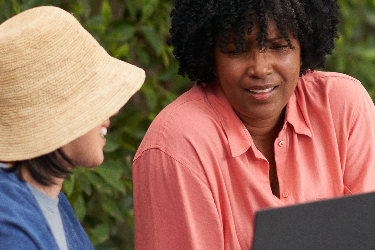 Due donne parlano mentre usano un laptop PCSpecialist con Windows 11