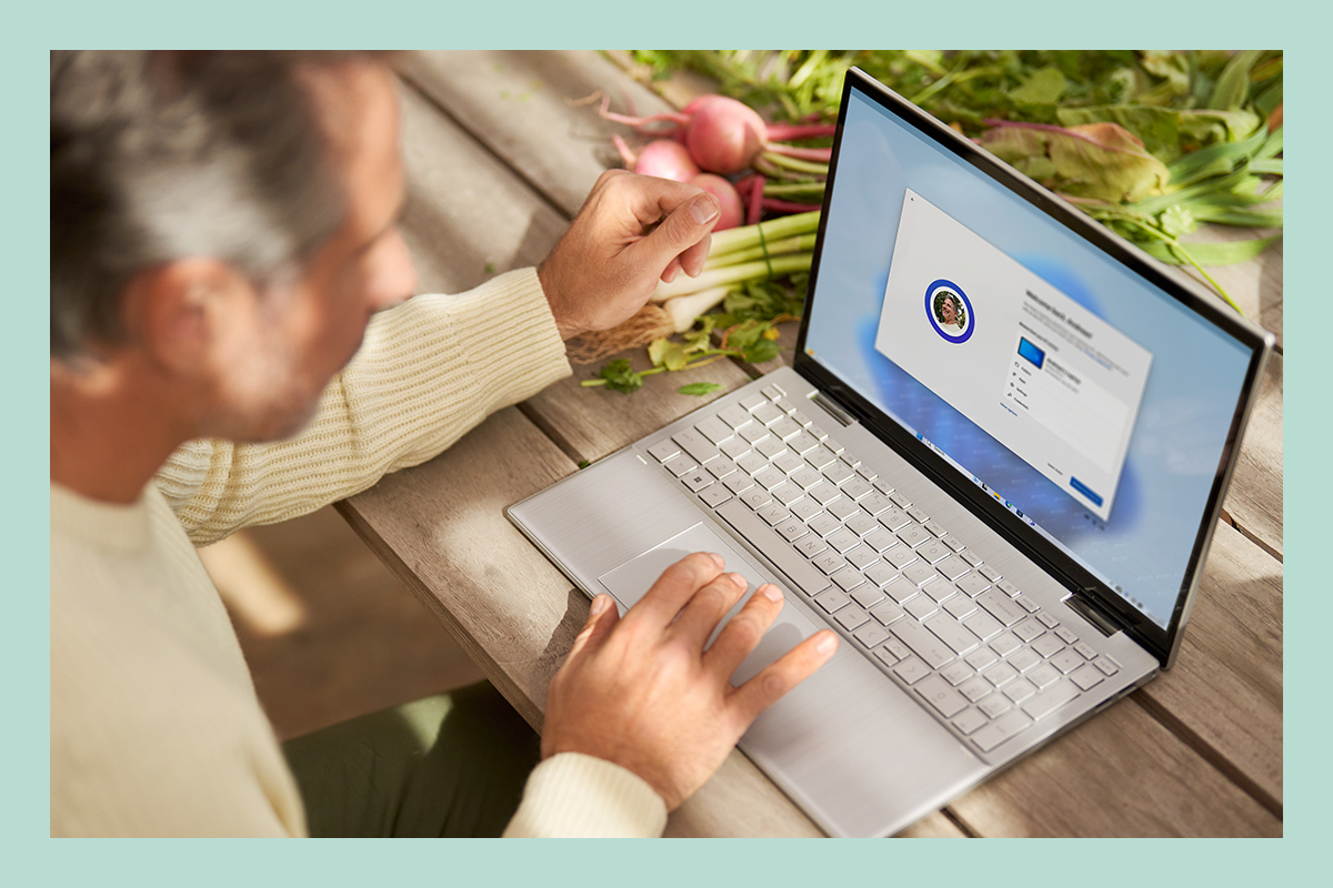 Un uomo usa un laptop e configura file e app già presenti e le impostazioni predefinite tramite Windows 11.